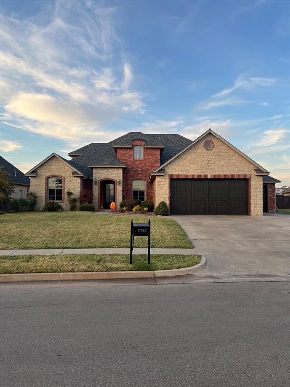 view of front of property featuring a garage and a front lawn