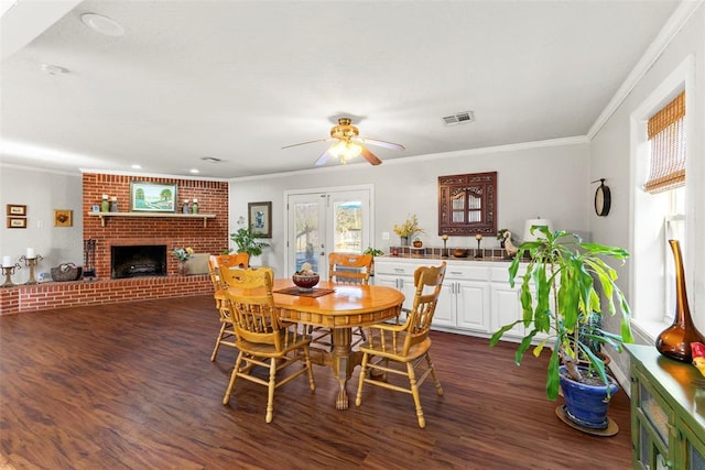 dining space featuring ceiling fan, french doors, a fireplace, and dark wood-type flooring