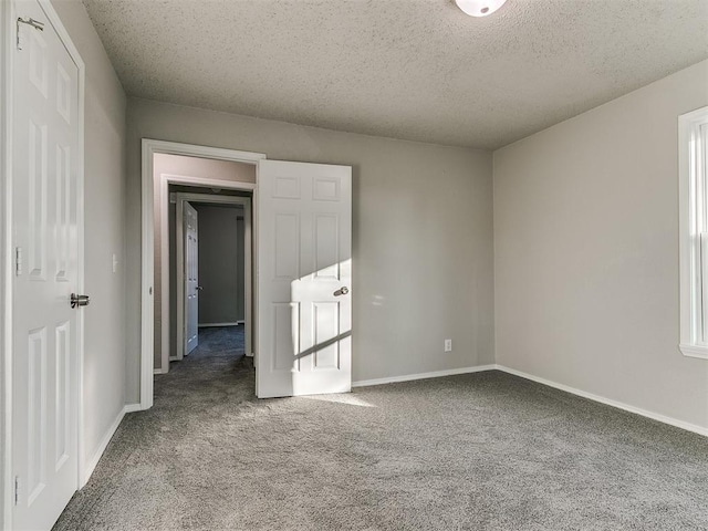 unfurnished room featuring carpet flooring and a textured ceiling