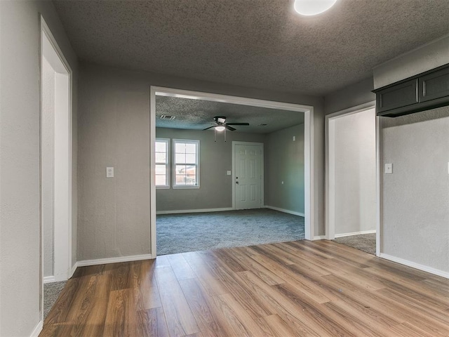 unfurnished room with ceiling fan, a textured ceiling, and hardwood / wood-style flooring