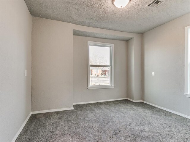 carpeted spare room featuring a textured ceiling