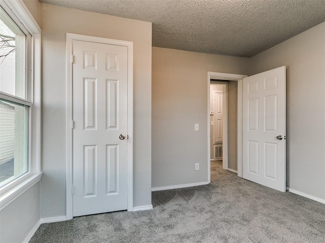 unfurnished bedroom featuring light carpet and a textured ceiling