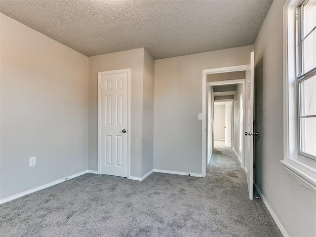 unfurnished bedroom featuring a textured ceiling and light colored carpet