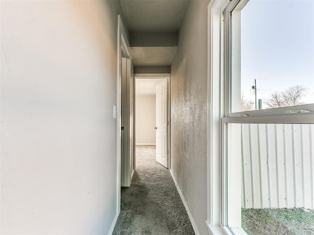 corridor featuring dark colored carpet