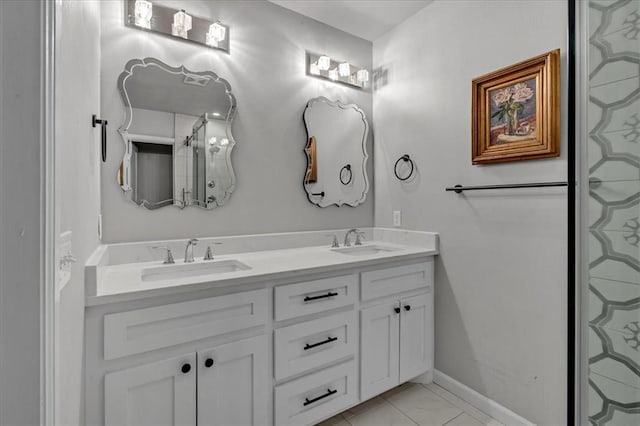 full bath featuring double vanity, a sink, and baseboards