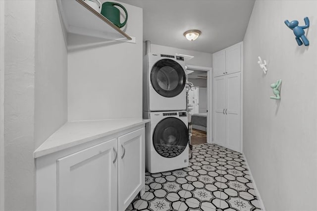 laundry room with cabinets and stacked washer / drying machine