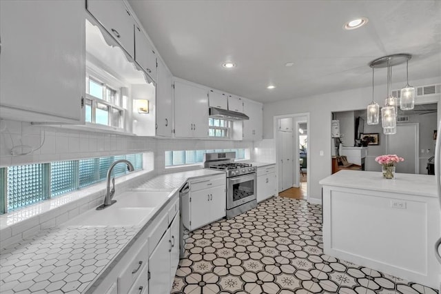 kitchen featuring stainless steel appliances, pendant lighting, white cabinetry, and sink