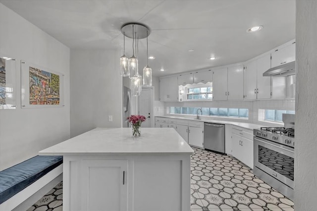 kitchen with hanging light fixtures, white cabinets, tasteful backsplash, and stainless steel appliances