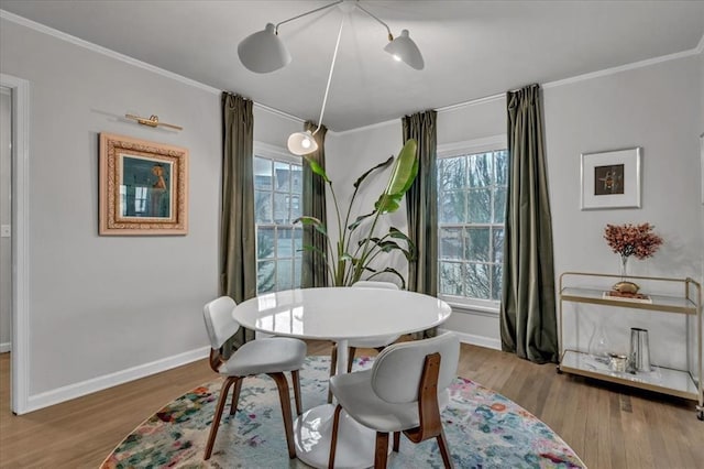 dining area featuring ornamental molding and light hardwood / wood-style flooring