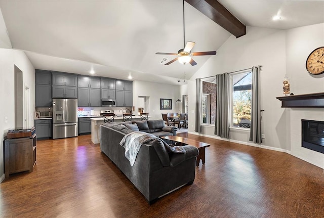 living room featuring ceiling fan, dark hardwood / wood-style floors, beam ceiling, and high vaulted ceiling