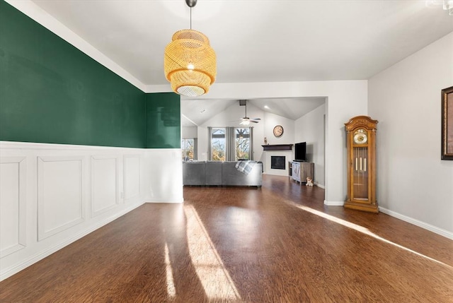 unfurnished living room featuring dark hardwood / wood-style floors, vaulted ceiling, and ceiling fan