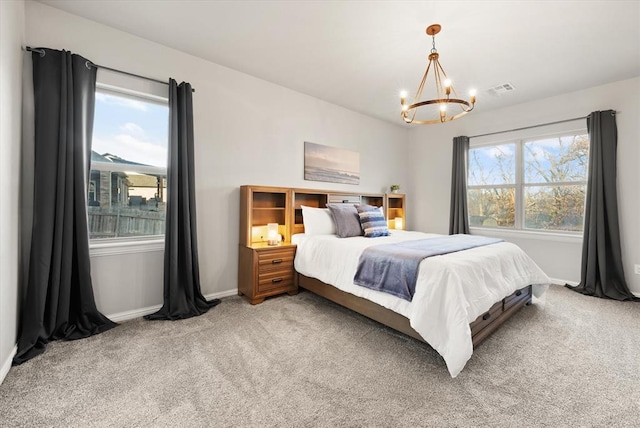 bedroom with carpet floors and an inviting chandelier