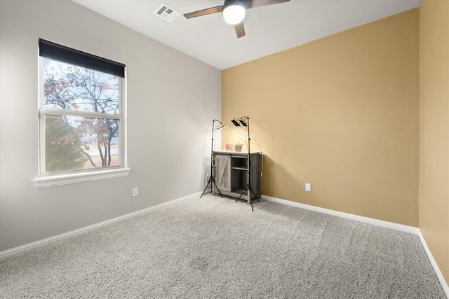 spare room with ceiling fan and carpet