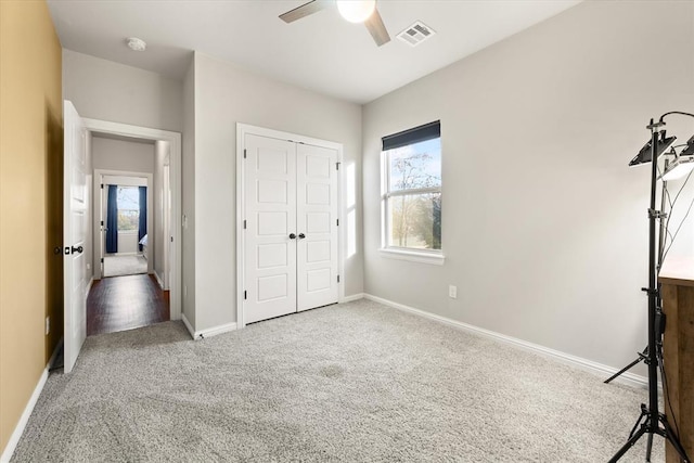 unfurnished bedroom with carpet floors, a closet, and ceiling fan