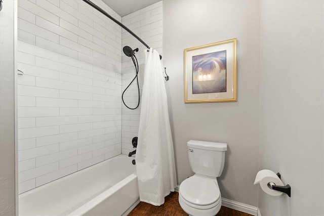 bathroom with hardwood / wood-style floors, toilet, and shower / bath combination with curtain