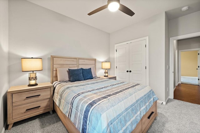 bedroom with ceiling fan, dark carpet, and a closet