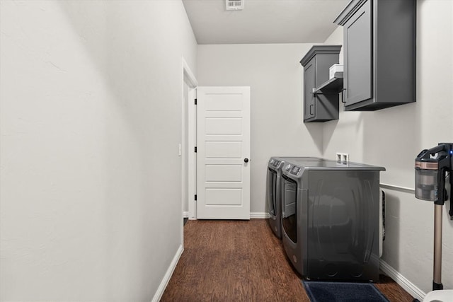 washroom with cabinets, separate washer and dryer, and dark wood-type flooring