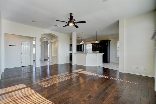 unfurnished living room featuring dark hardwood / wood-style flooring and ceiling fan