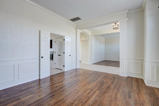 empty room with hardwood / wood-style floors and crown molding