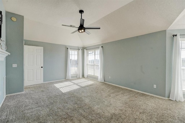 spare room featuring ceiling fan, a healthy amount of sunlight, light colored carpet, and lofted ceiling