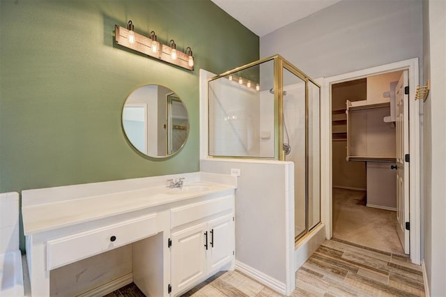 bathroom featuring vanity, a shower with shower door, and wood-type flooring