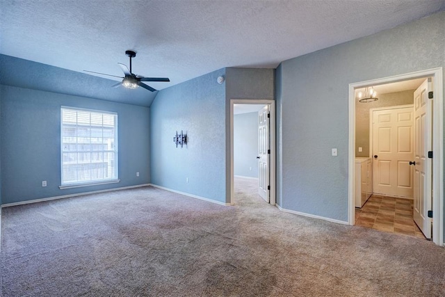 interior space featuring ceiling fan with notable chandelier, light colored carpet, a textured ceiling, and vaulted ceiling