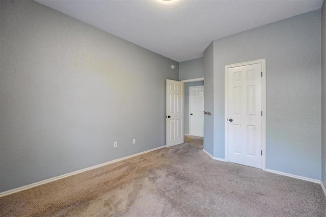 unfurnished bedroom with light colored carpet and a closet