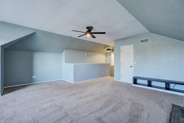 bonus room featuring carpet flooring, ceiling fan, lofted ceiling, and a textured ceiling