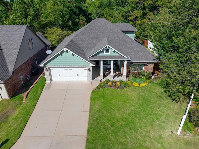 view of front of home featuring a porch, a garage, and a front lawn