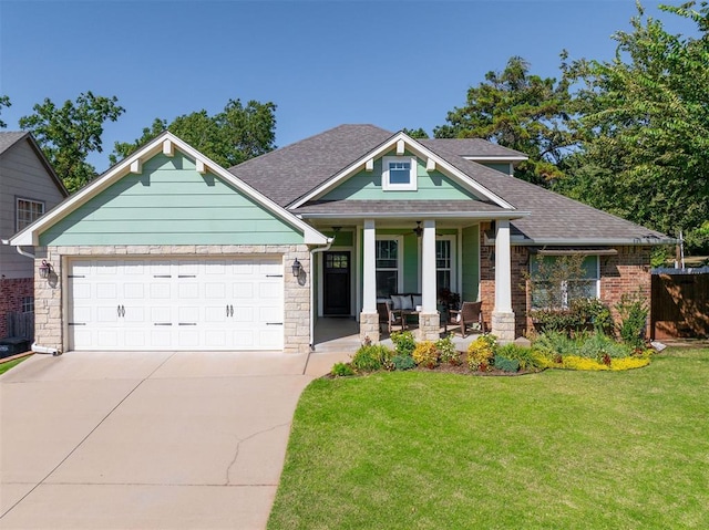 craftsman house featuring a porch, a garage, and a front lawn