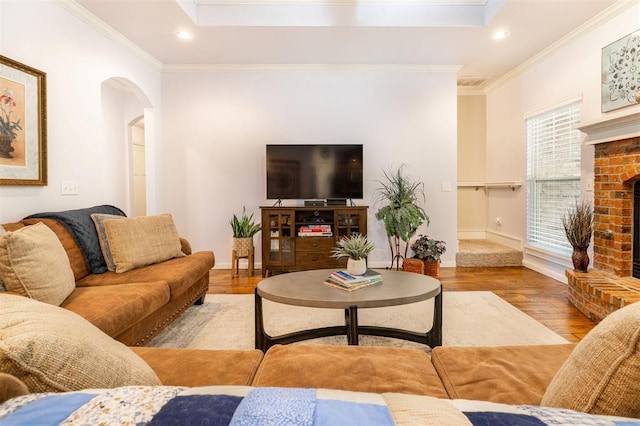 living room with a fireplace, light hardwood / wood-style floors, and ornamental molding