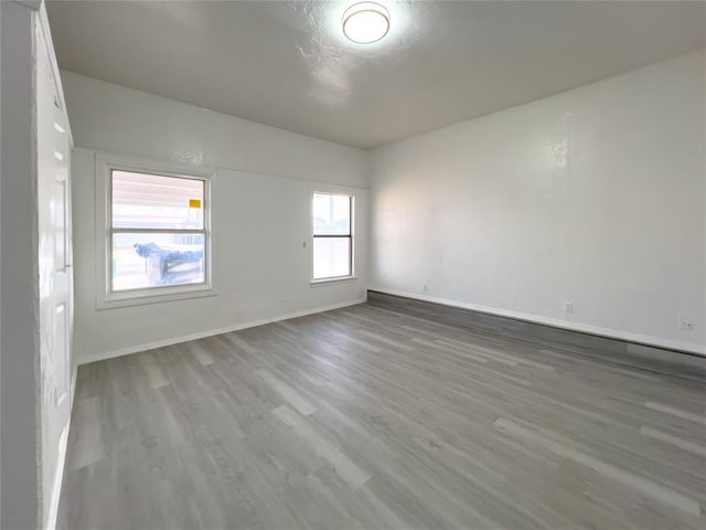 empty room with baseboards and wood finished floors