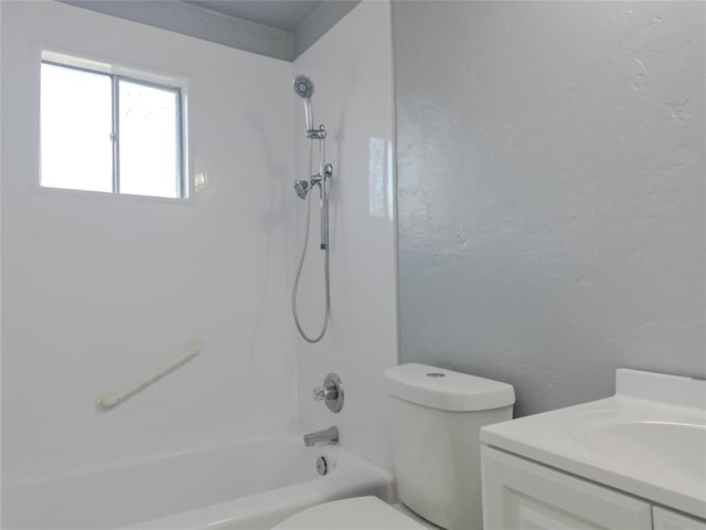 full bath featuring a textured wall, shower / tub combination, vanity, and toilet