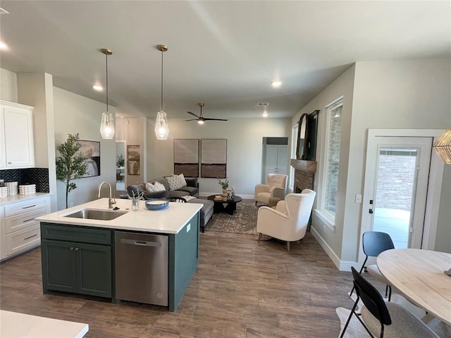 kitchen featuring white cabinetry, sink, stainless steel dishwasher, and decorative light fixtures