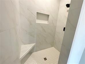 bathroom featuring a tile shower