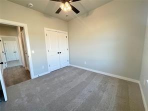 unfurnished bedroom featuring dark carpet, a closet, and ceiling fan