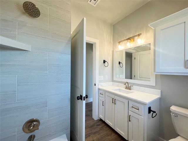 full bathroom featuring hardwood / wood-style flooring, vanity, toilet, and tiled shower / bath combo