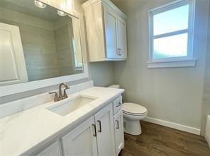 full bathroom with wood-type flooring, vanity, shower with separate bathtub, and toilet