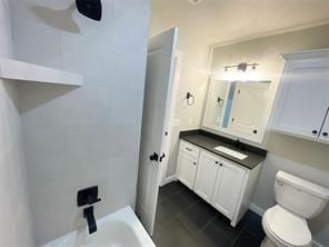 bathroom with vanity, toilet, and a tub