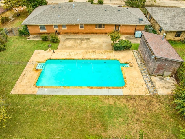 view of swimming pool featuring a patio area and a yard