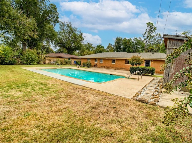 view of swimming pool featuring a lawn and a patio area