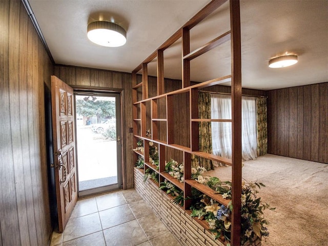 entryway with light colored carpet and wood walls