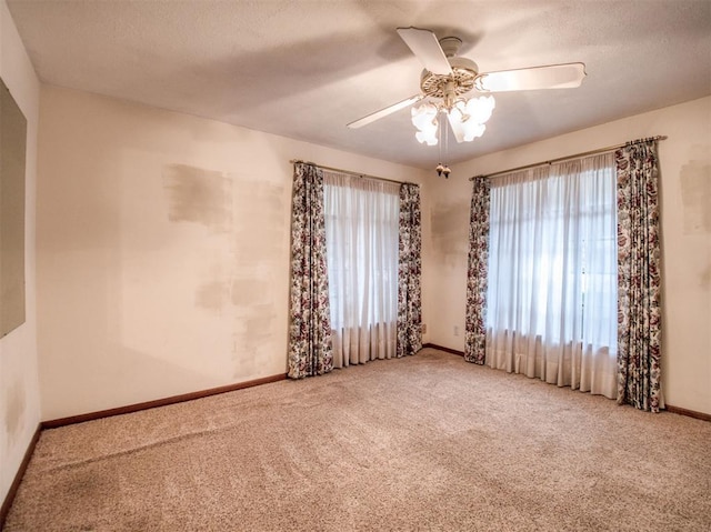 carpeted empty room with a textured ceiling and ceiling fan