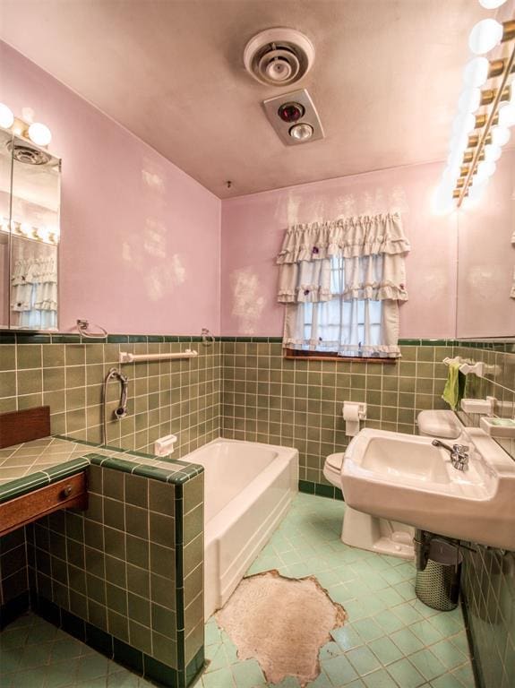 bathroom with toilet, tile patterned flooring, tile walls, and a tub to relax in