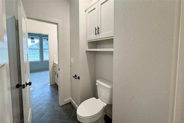 9224 NW 83rd St, Yukon, OK 73099 - bathroom featuring toilet, baseboards, and a textured wall