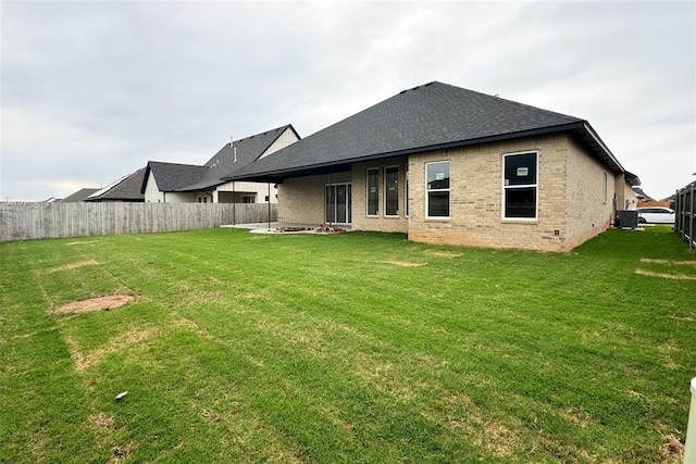 9224 NW 83rd St, Yukon, OK 73099 - back of property with brick siding, a shingled roof, an outdoor fire pit, and central AC