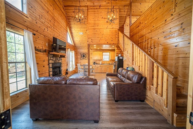 unfurnished living room featuring wooden ceiling, high vaulted ceiling, a stone fireplace, wooden walls, and dark hardwood / wood-style flooring