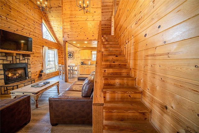 living room with wooden walls, high vaulted ceiling, wooden ceiling, a notable chandelier, and hardwood / wood-style floors