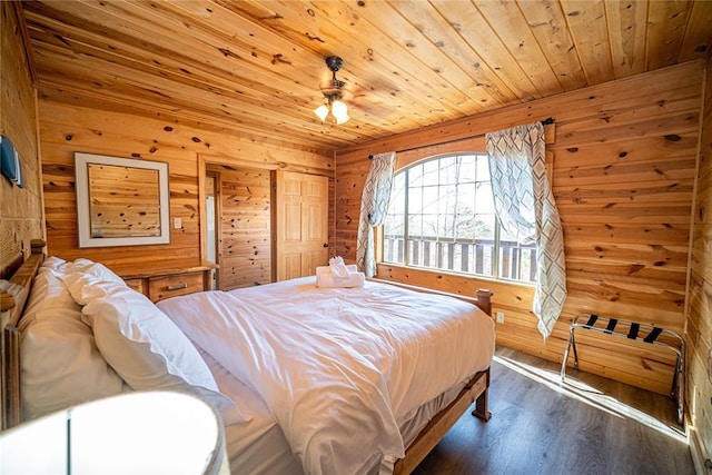 bedroom featuring wooden walls, ceiling fan, dark wood-type flooring, and wood ceiling