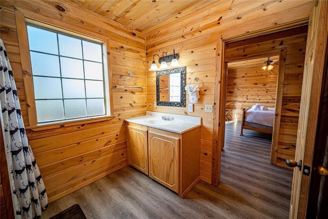 bathroom with hardwood / wood-style floors, vanity, wood walls, and wood ceiling